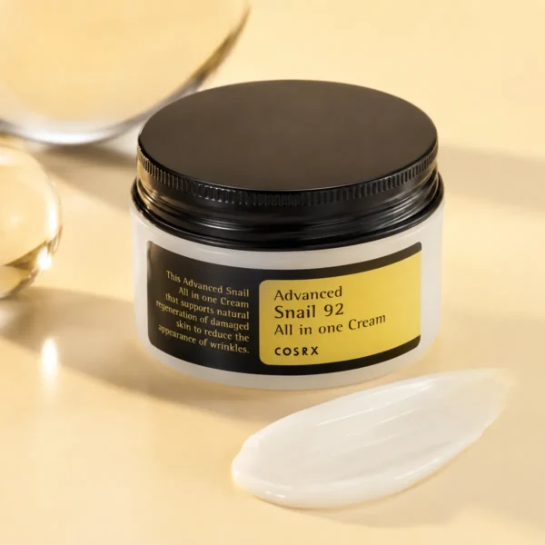 cosrx-advanced-snail-92-all-in-one-cream-100ml-real-product-still-life COSRX Advanced Snail 92 All In One Cream 100ml real product still life with snail cream jar and soft yellow lighting
